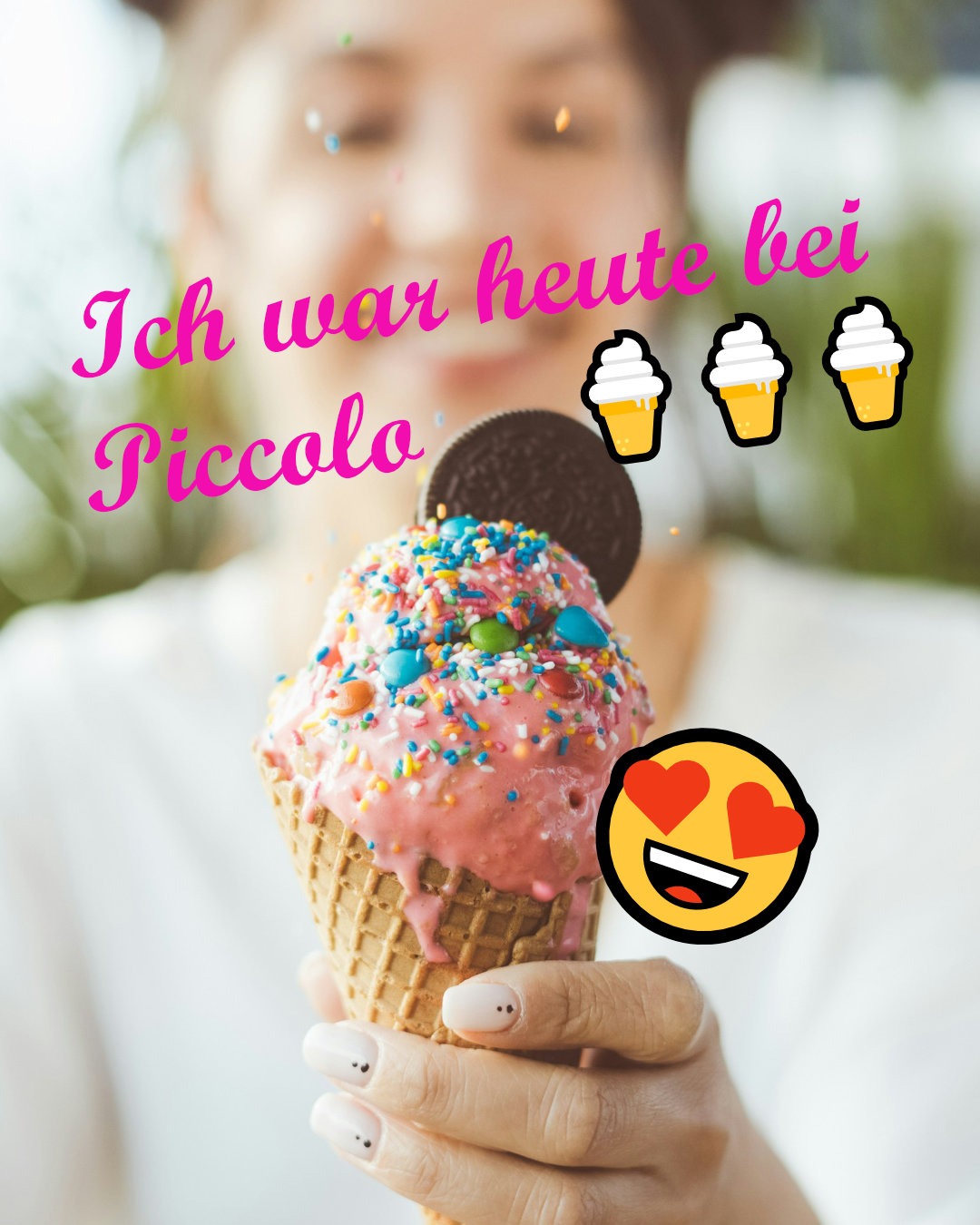 Eine lächelnde Person hält eine Waffel mit rosa Eis, das mit bunten Streuseln, Schokolinsen und einem Oreo-Keks dekoriert ist. Auf dem Bild steht in pinker Schrift „Ich war heute bei Piccolo“, ergänzt durch Eis- und Herzaugen-Emojis.