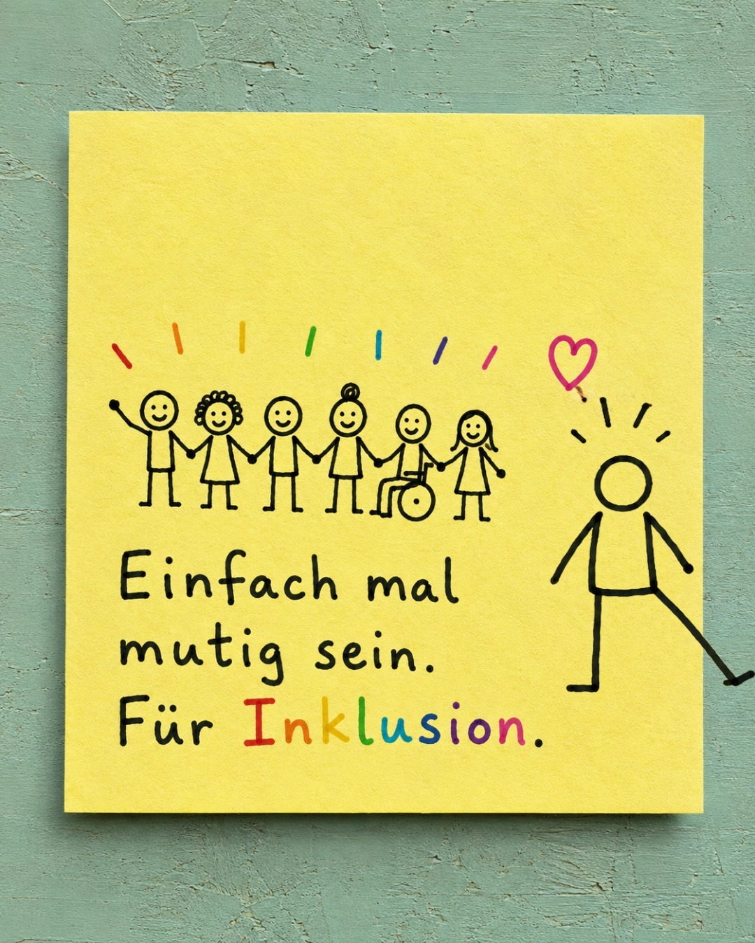 Ein gelber Notizzettel auf grünem Hintergrund zeigt eine handgezeichnete Gruppe von Strichmännchen, die sich an den Händen halten – darunter eine Person im Rollstuhl – sowie eine einzelne Figur mit Herz rechts daneben. Darunter steht der Text „Einfach mal mutig sein. Für Inklusion.", wobei das Wort „Inklusion" in Regenbogenfarben geschrieben ist.